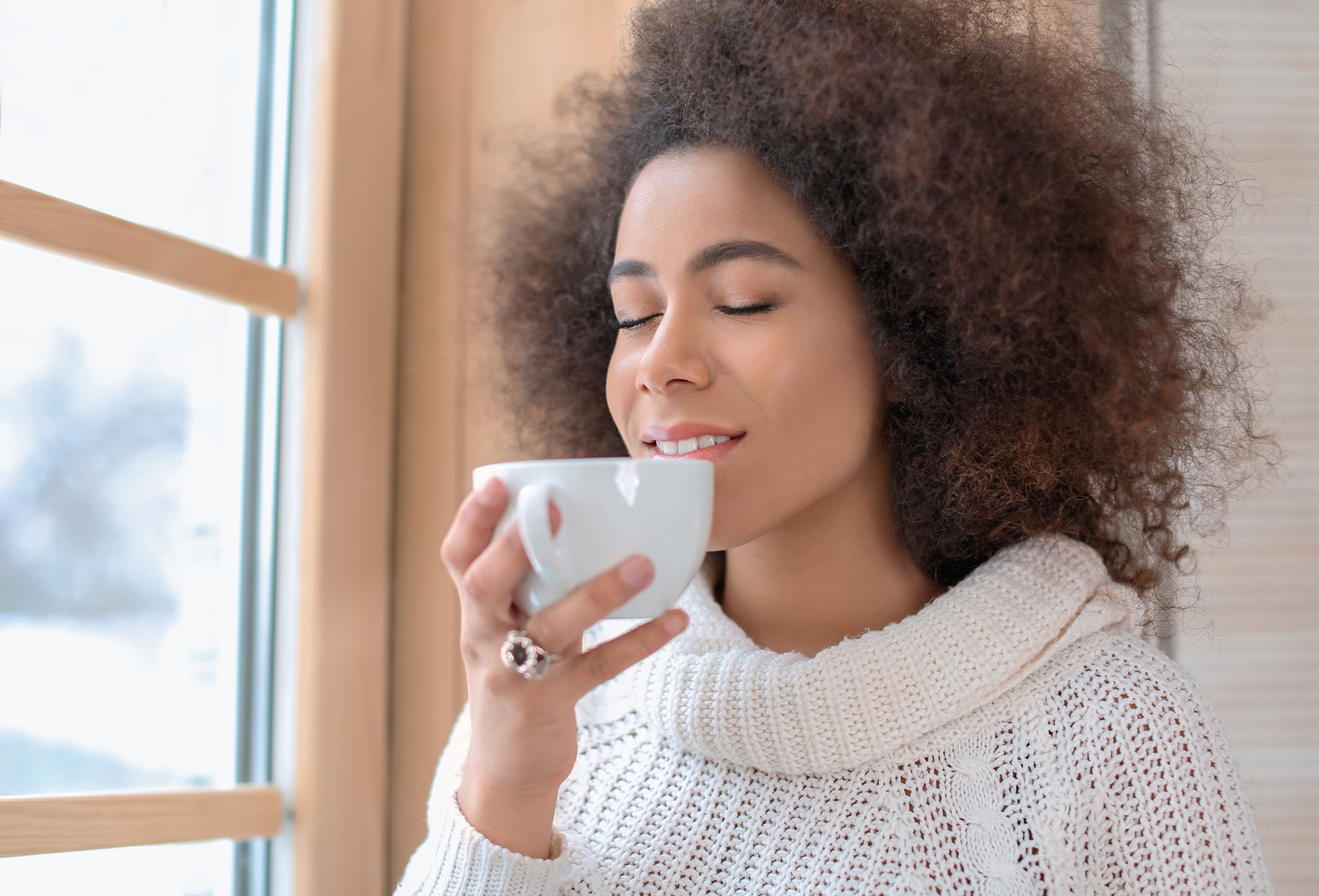 Beautiful Black African American woman drinking tea in winter near window- VERGE Lifestyle Magazine Digital Issue